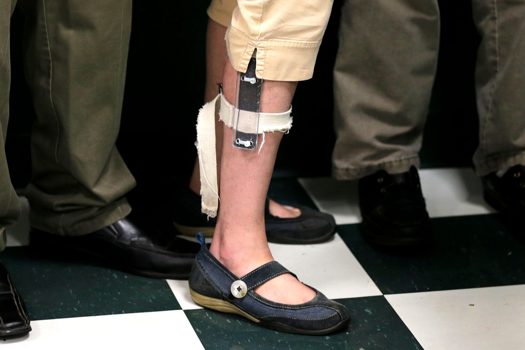 A female student wears a shocking device on her leg.