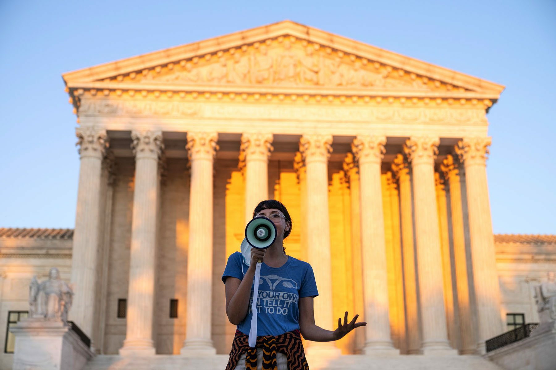 An abortion rights activist speaks outside the Supreme Court.