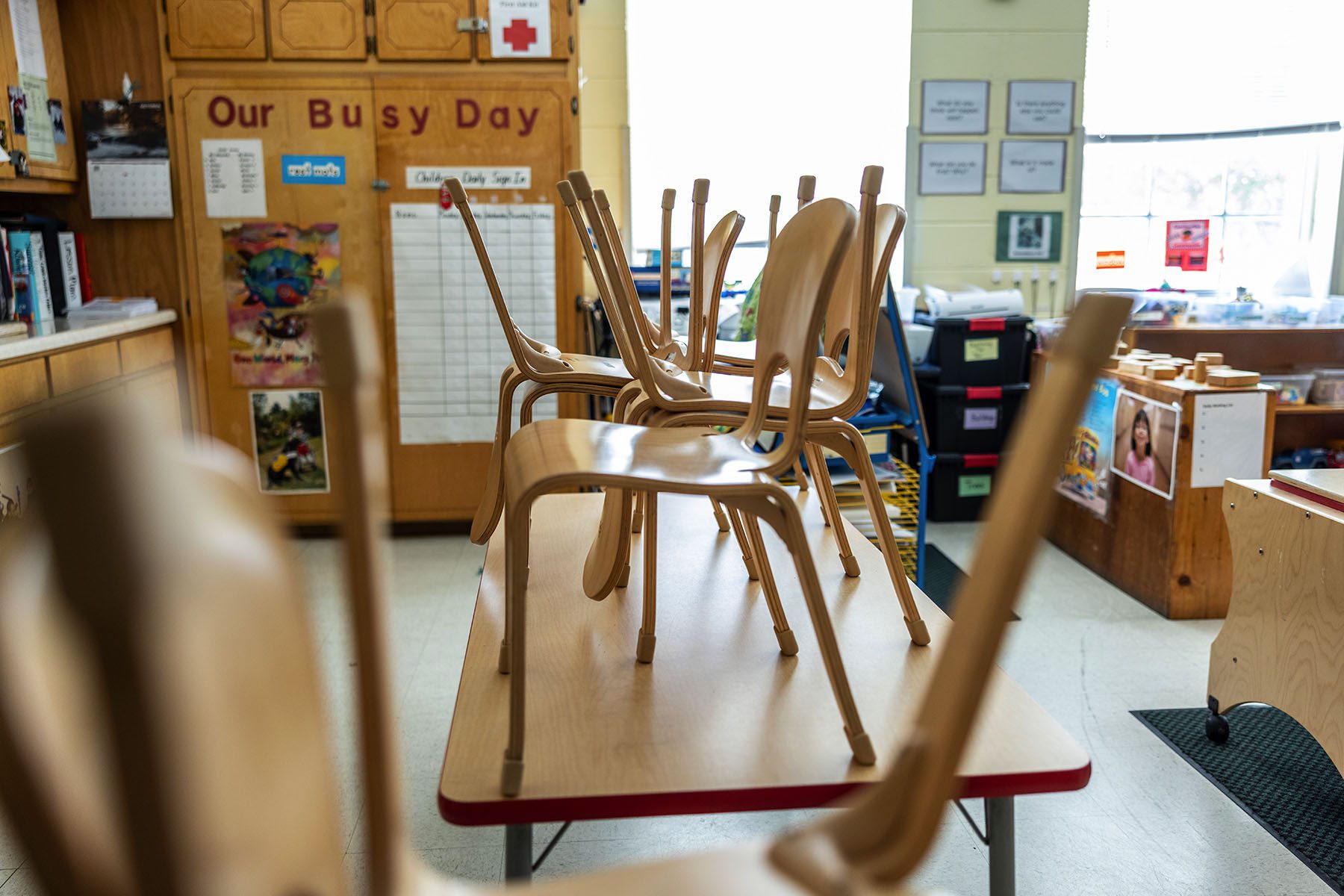 Wooden chairs are stacked on top of tables inside a classroom at the Chambliss Center for Children.