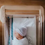 Newborn baby sleeping in a hospital bassinet