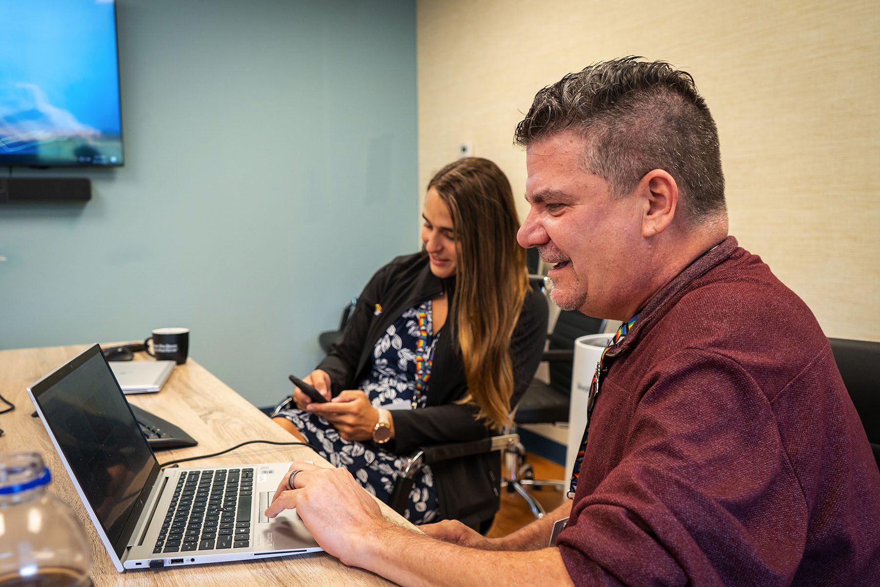 Dr. Cronyn smiles while working at a computer in a conference room.