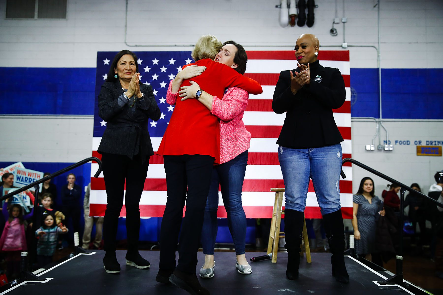 Warren hugs Katie Porter while Deb Haaland and Ayanna Pressley