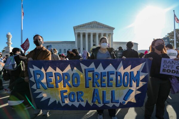 People carry a banner on reproductive freedom in front of the Supreme Court