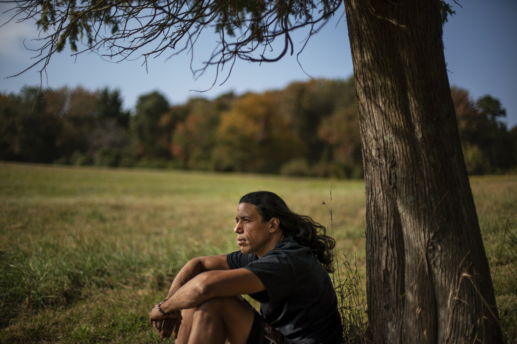 Annawon Weeden sits by a tree