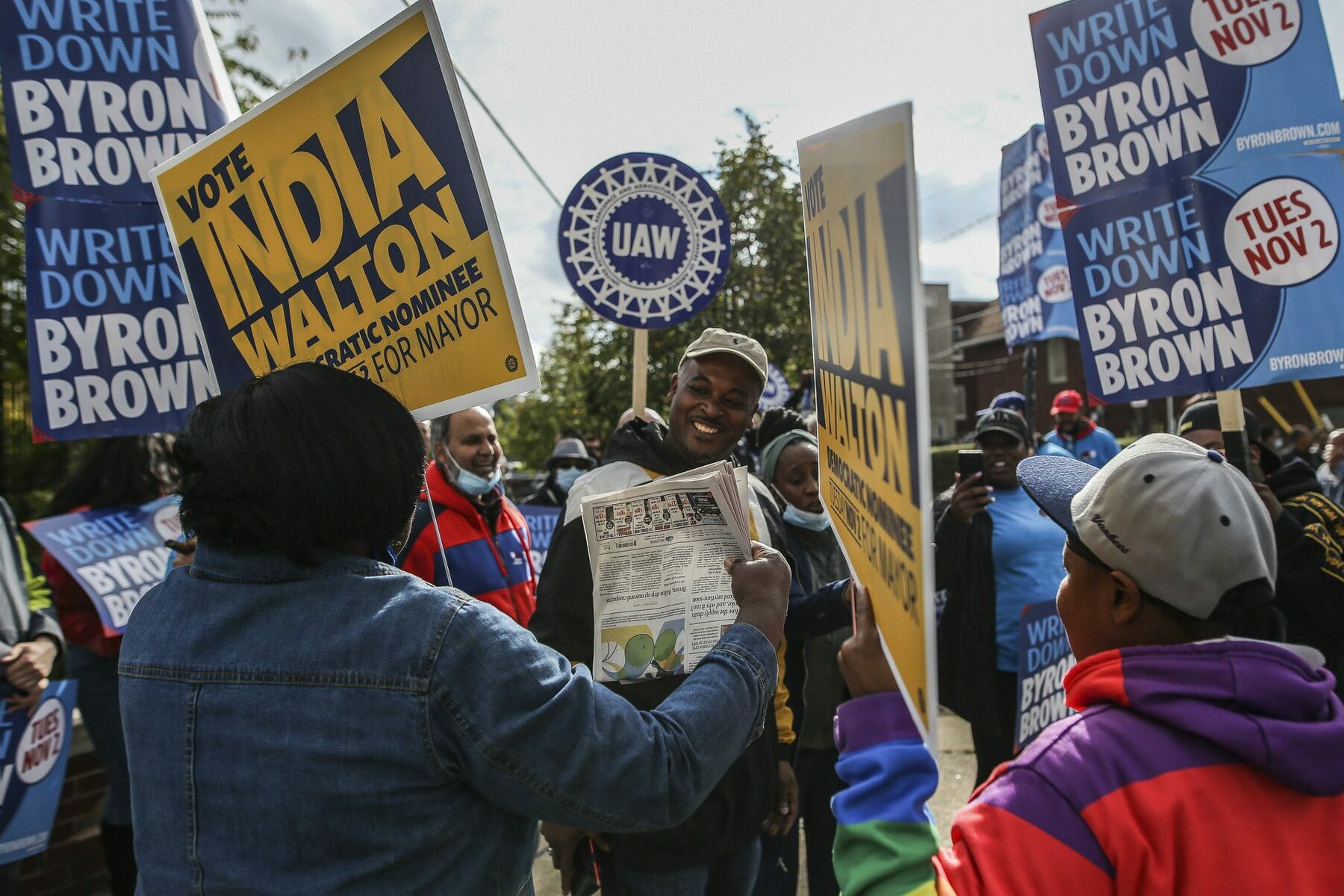 People hold signs for India Walton and Byron Brown in Buffalo