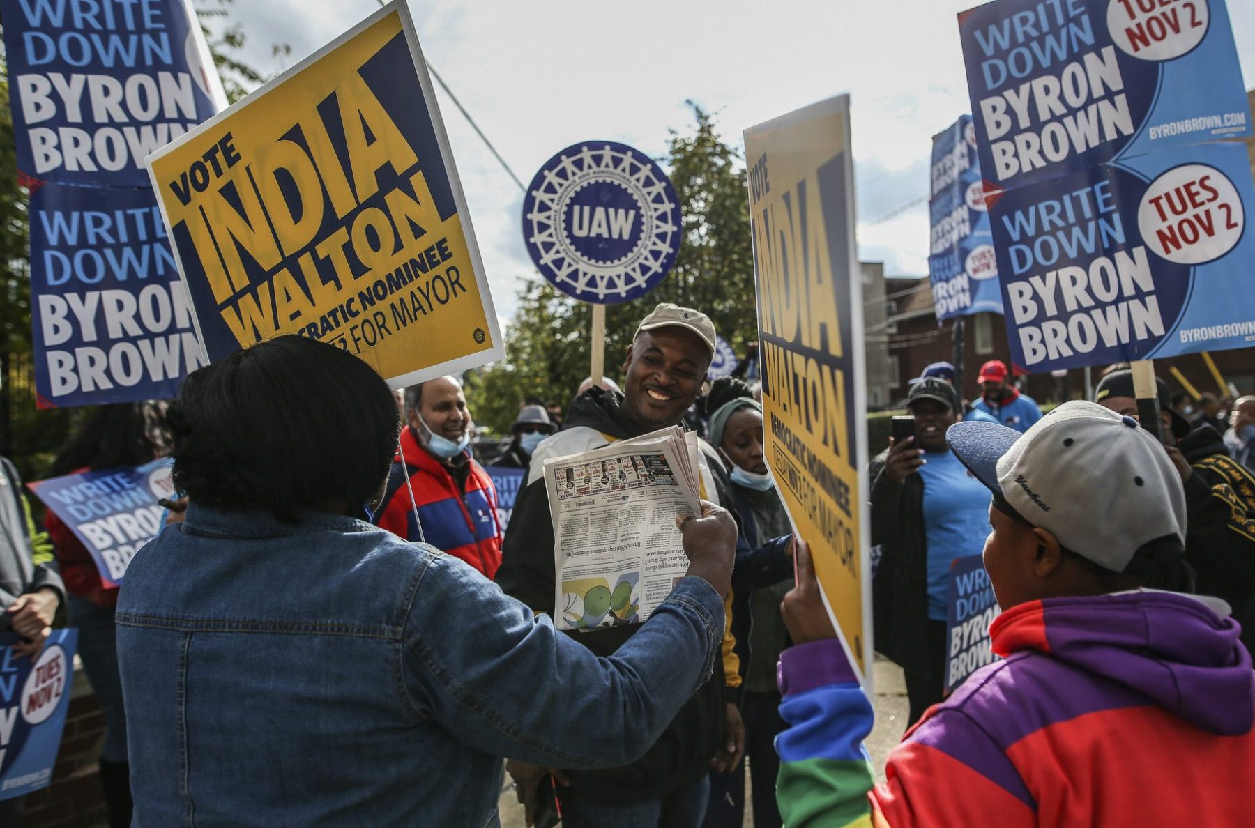 People hold signs for India Walton and Byron Brown in Buffalo