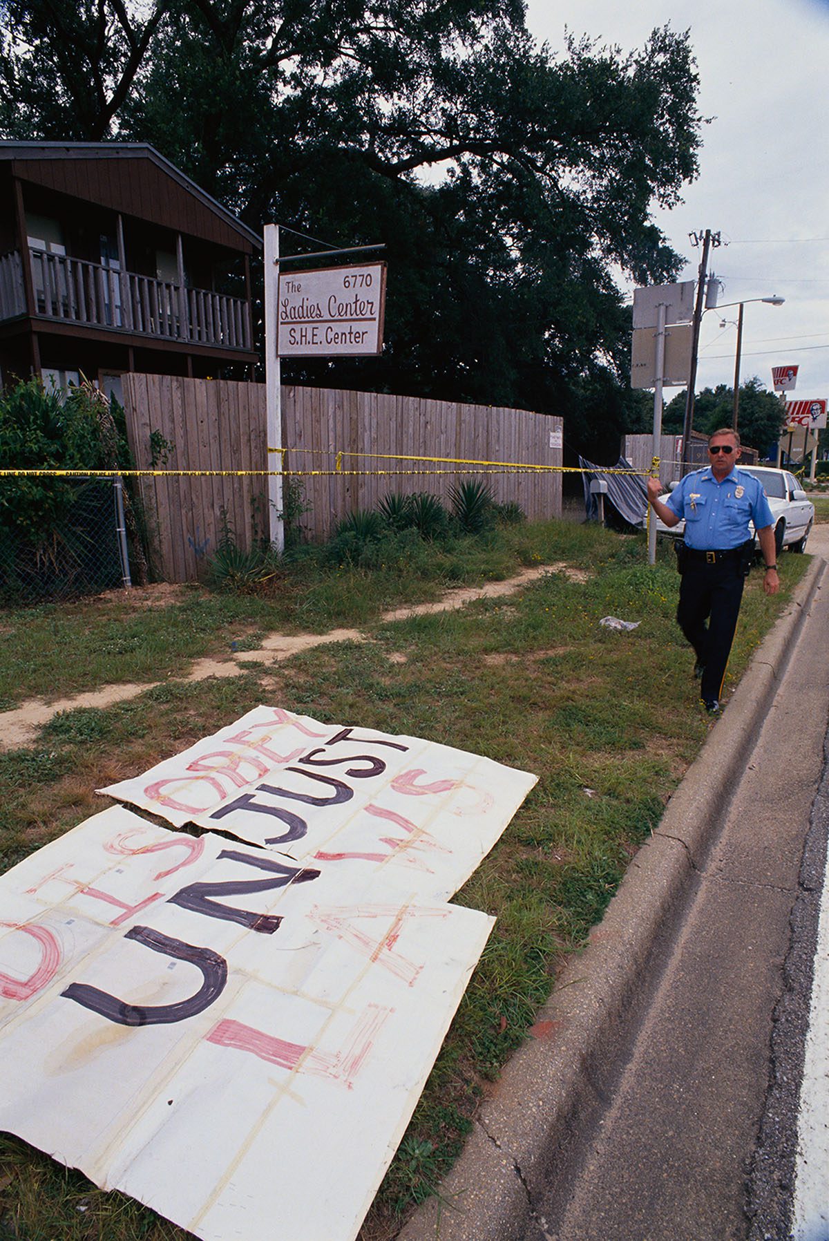 A policeman barricades the crime scene near The Ladies Center.