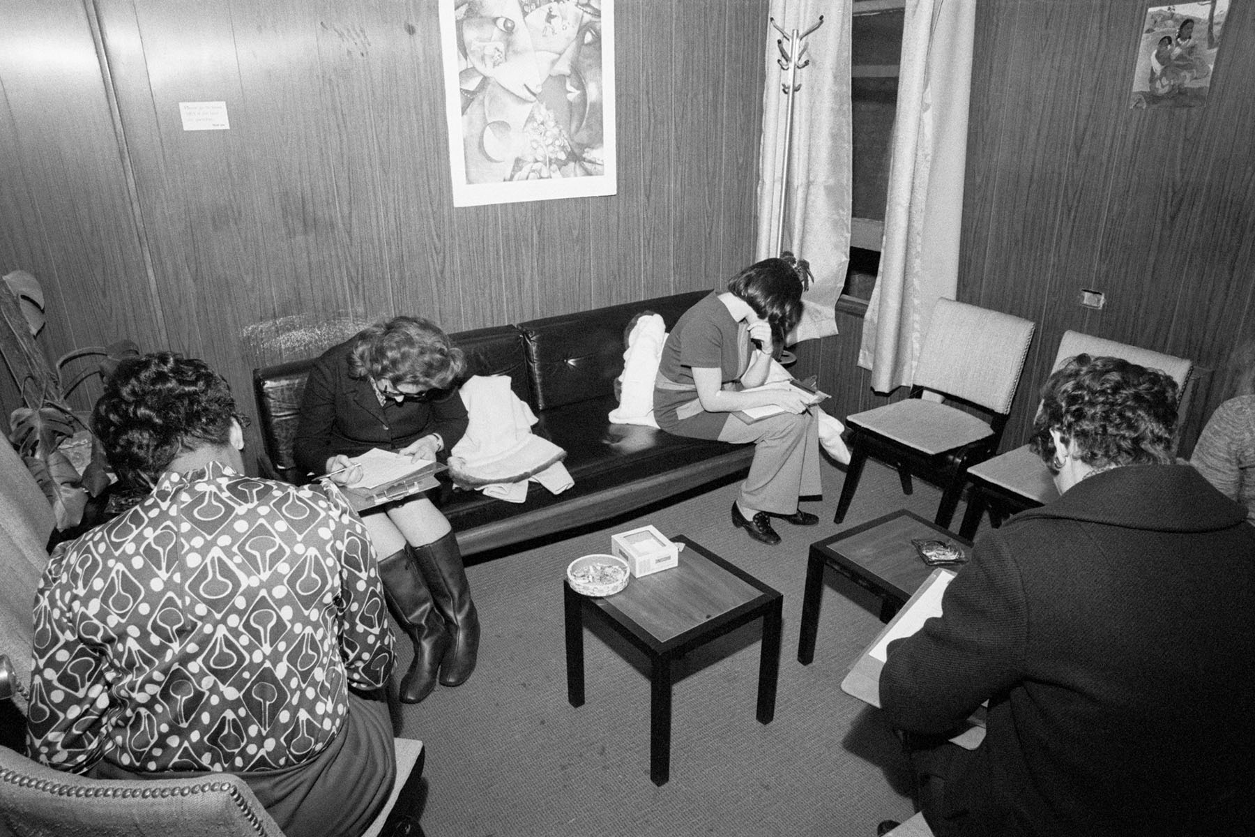 Women fill out forms in the waiting room.