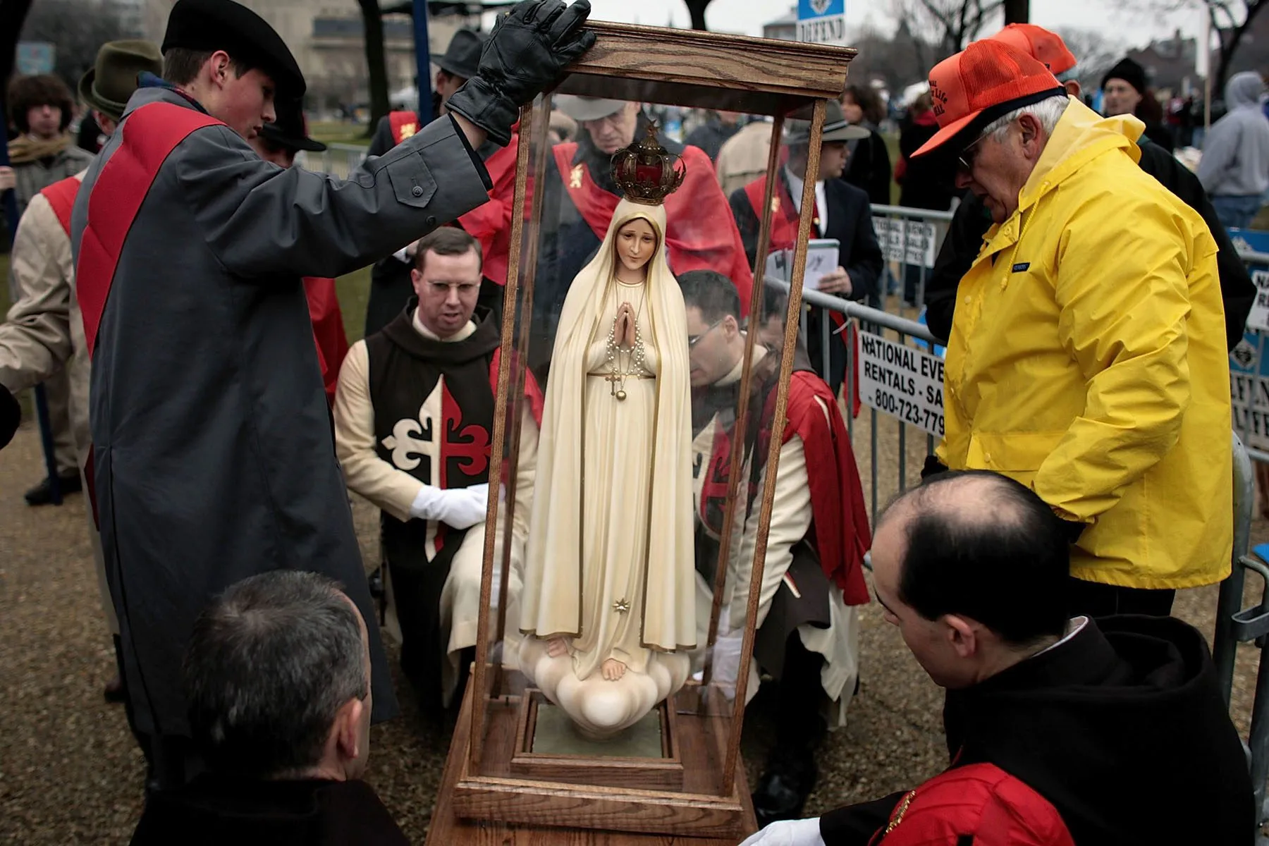 Demonstrators prepare to lift an encased statue of Lady Fatima.