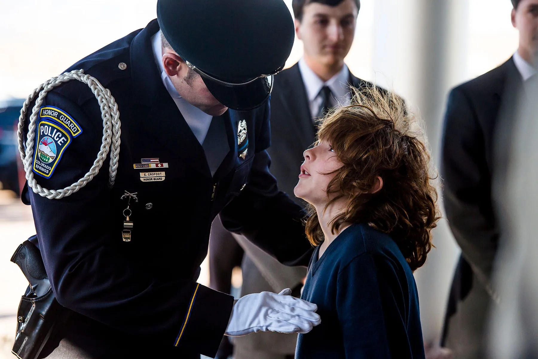 A young man is greeted by a member of the Honor Guard.
