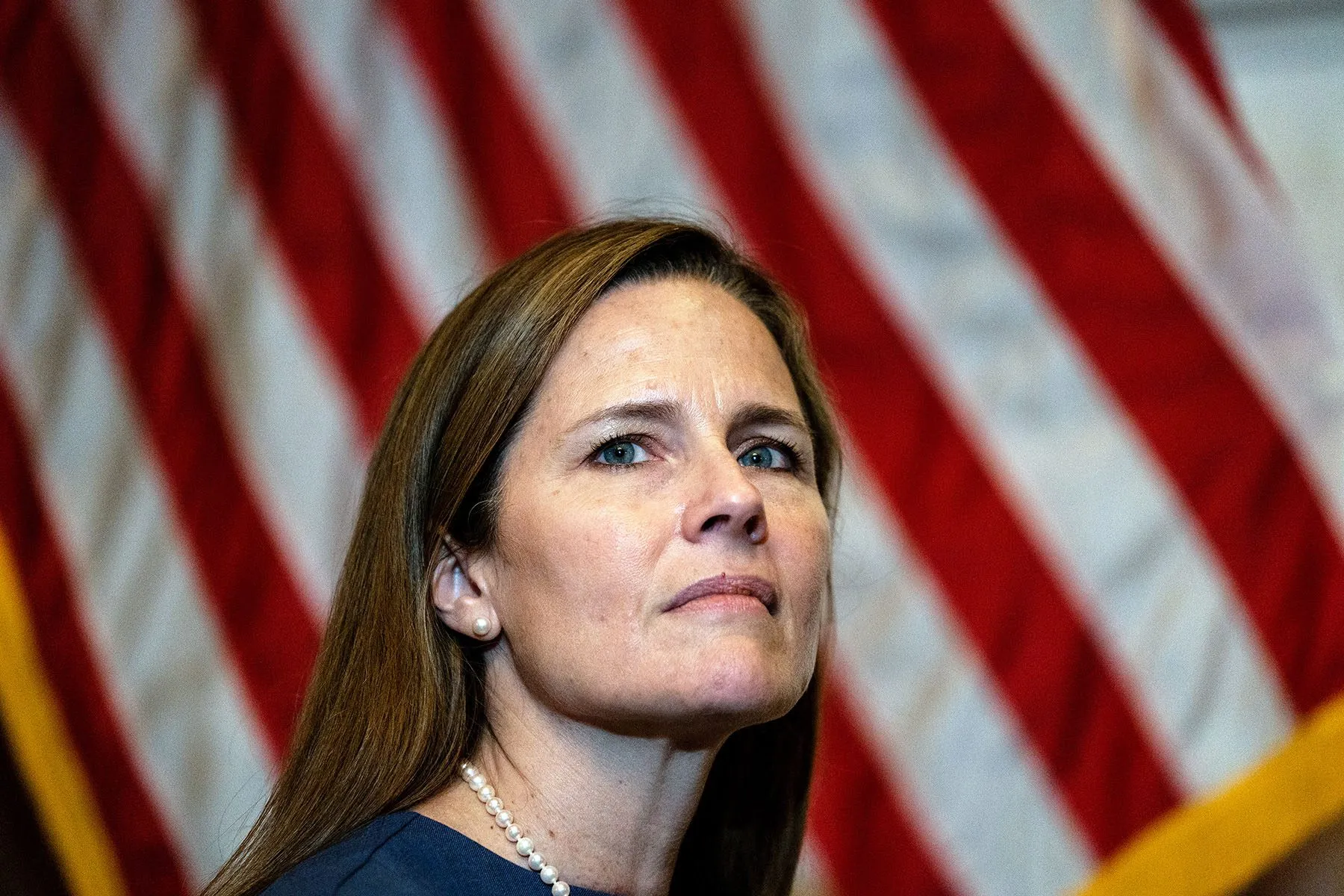 Amy Coney Barrett sits near an American Flag at the U.S. Capitol