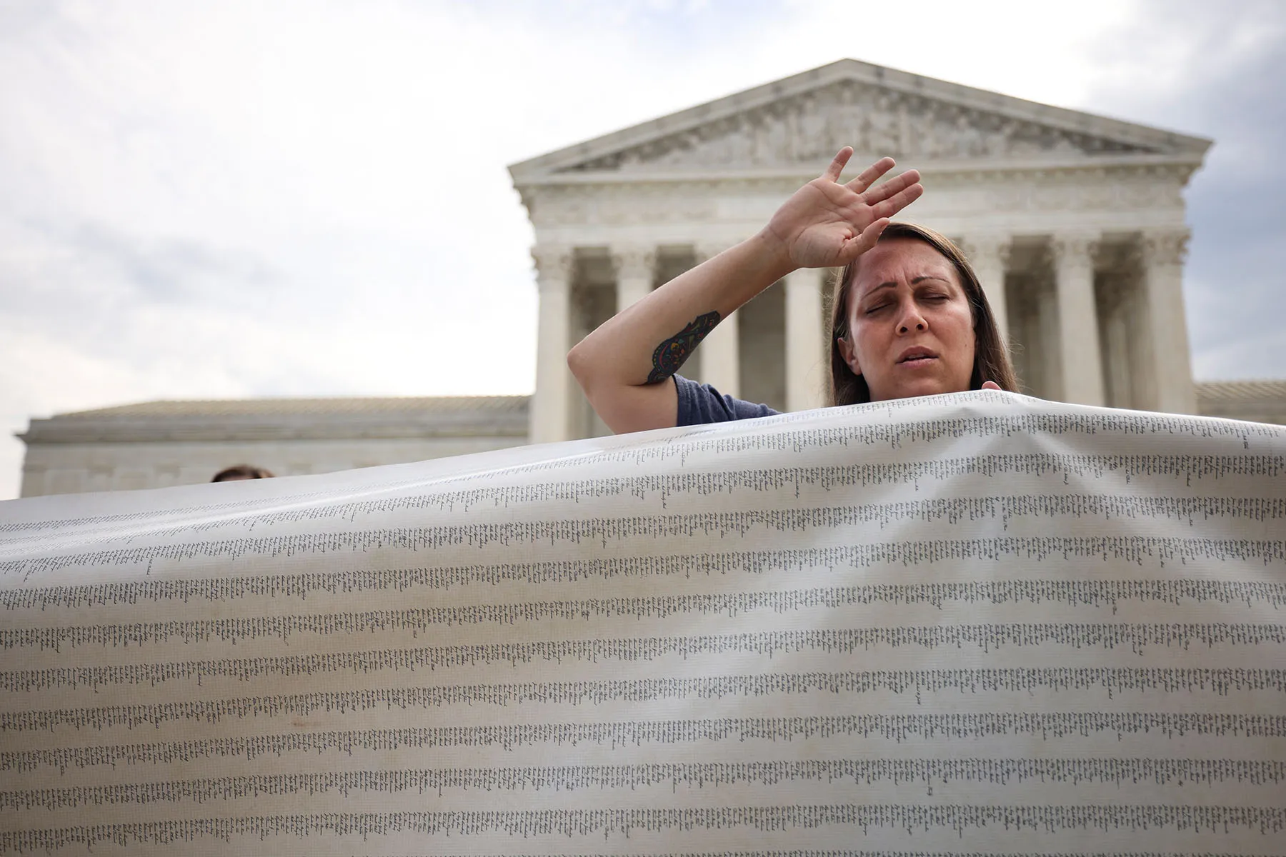 An anti-abortion activist holds a petition to end abortion outside of the Supreme Court.