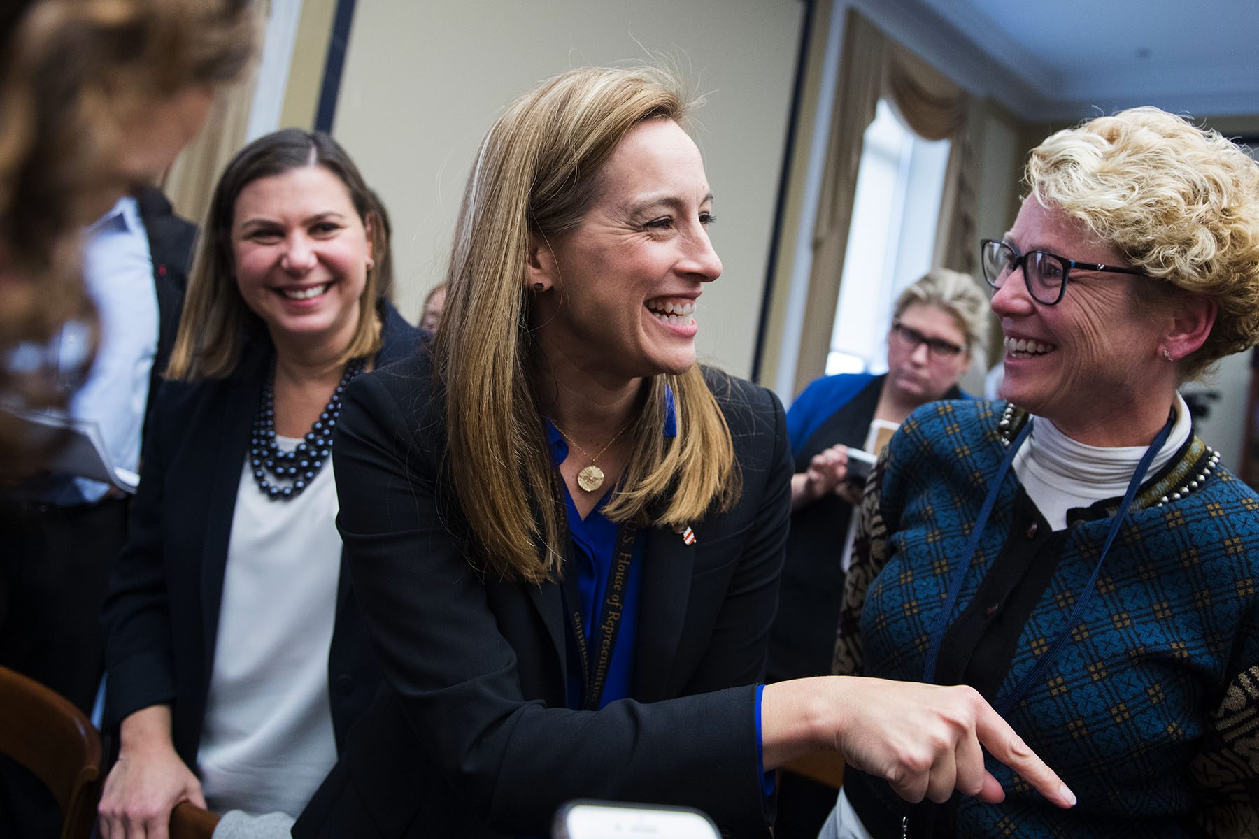 Chrissy Houlahan and Mikie Sherril laugh while they speak to each other on Capitol Hill.