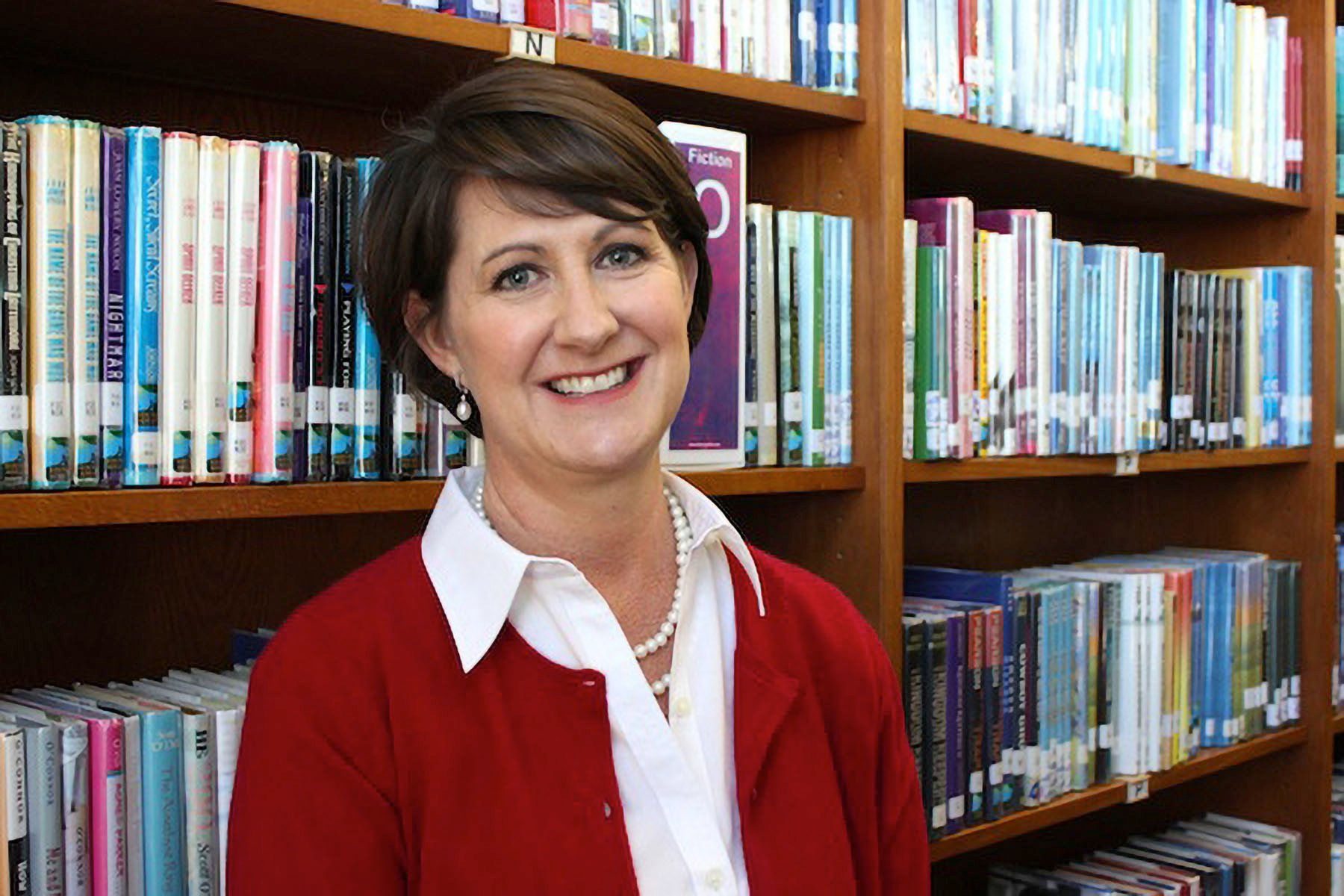 Jill Bellomy smiles in a school libraby.