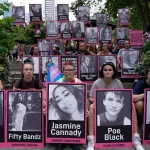People hold photos of murdered transgender people.