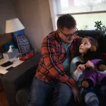Steve Ammidown hangs out with his daughter June at home in Bowling Green, OH on December 9, 2021. Ammidown quit his job during the pandemic to take on child care and spend more time with his daughter.