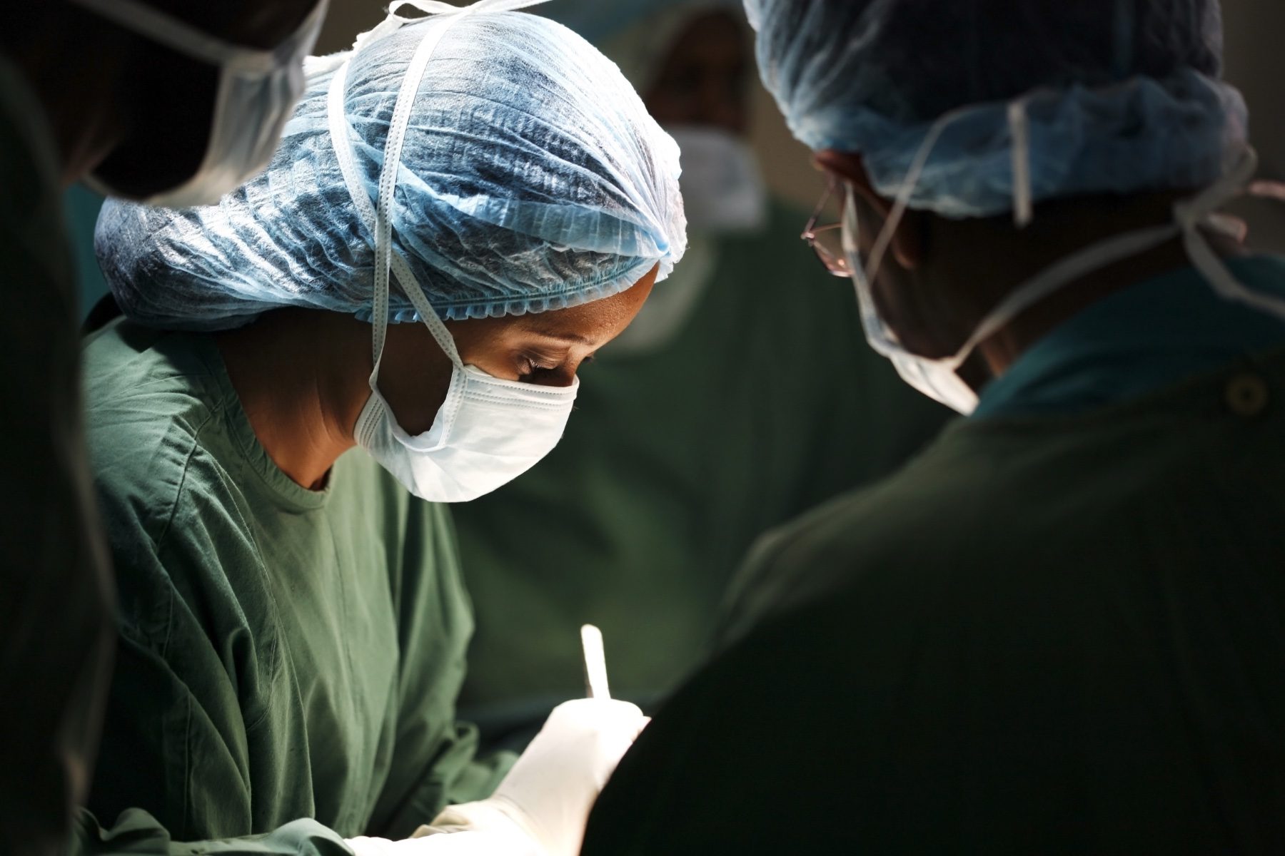 A woman surgeon and her assistants operating on a patient.