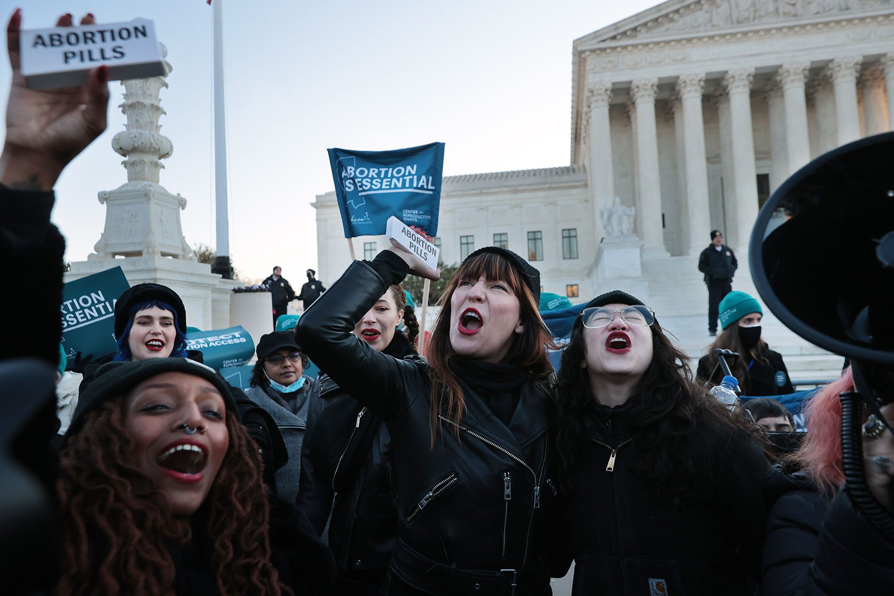 Demonstrators hold boxes of abortion pills in front of the U.S. Supreme Court.