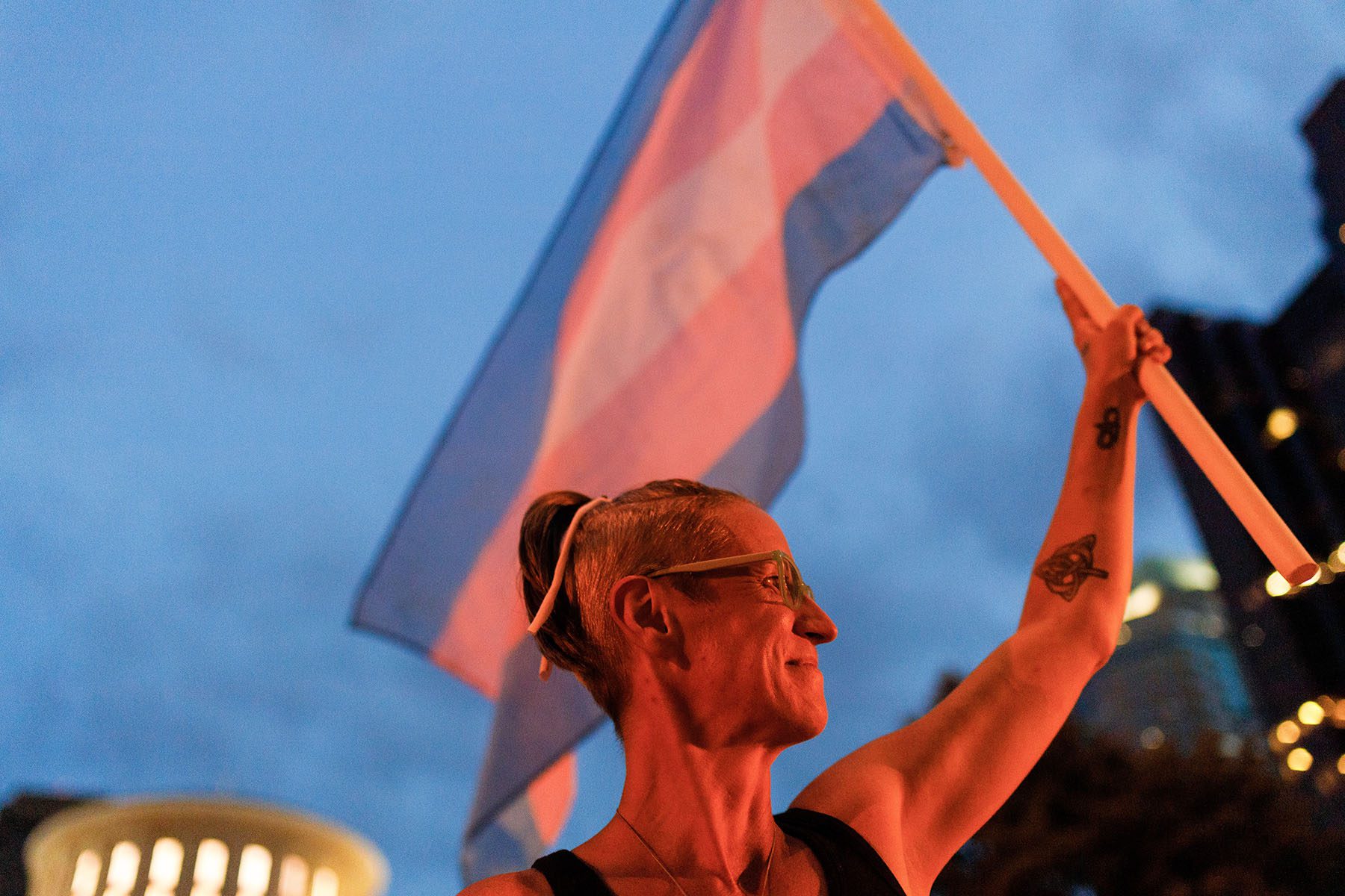 A person holds a transgender pride flag near the ohio statehouse in protest.