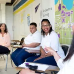 Incarcerated women in the midst of a group discussion in a classroom.