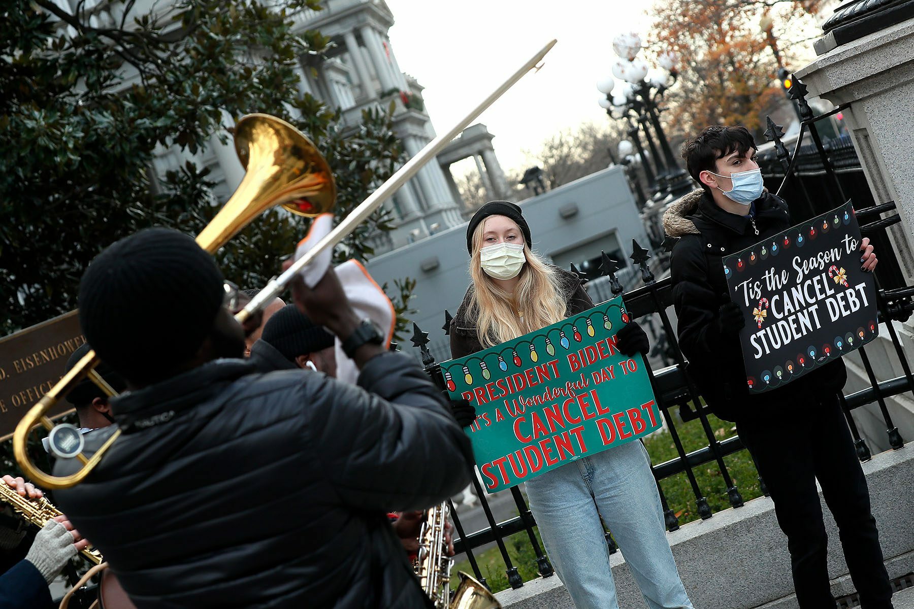 Activists hold signs calling on President Biden to cancel student debt near the White House.