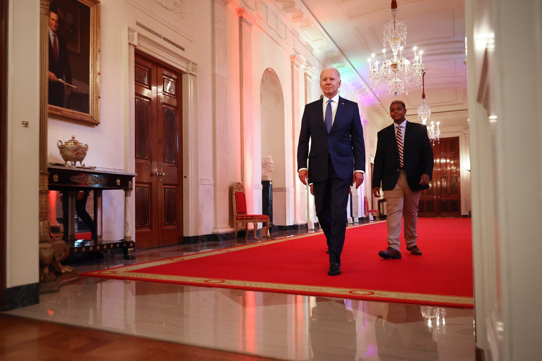 President Joe Biden and Human Rights Campaign youth ambassador Ashton Mota walk into the East Room for an event commemorating LGBTQ+ Pride Month at the White House on June 25, 2021.