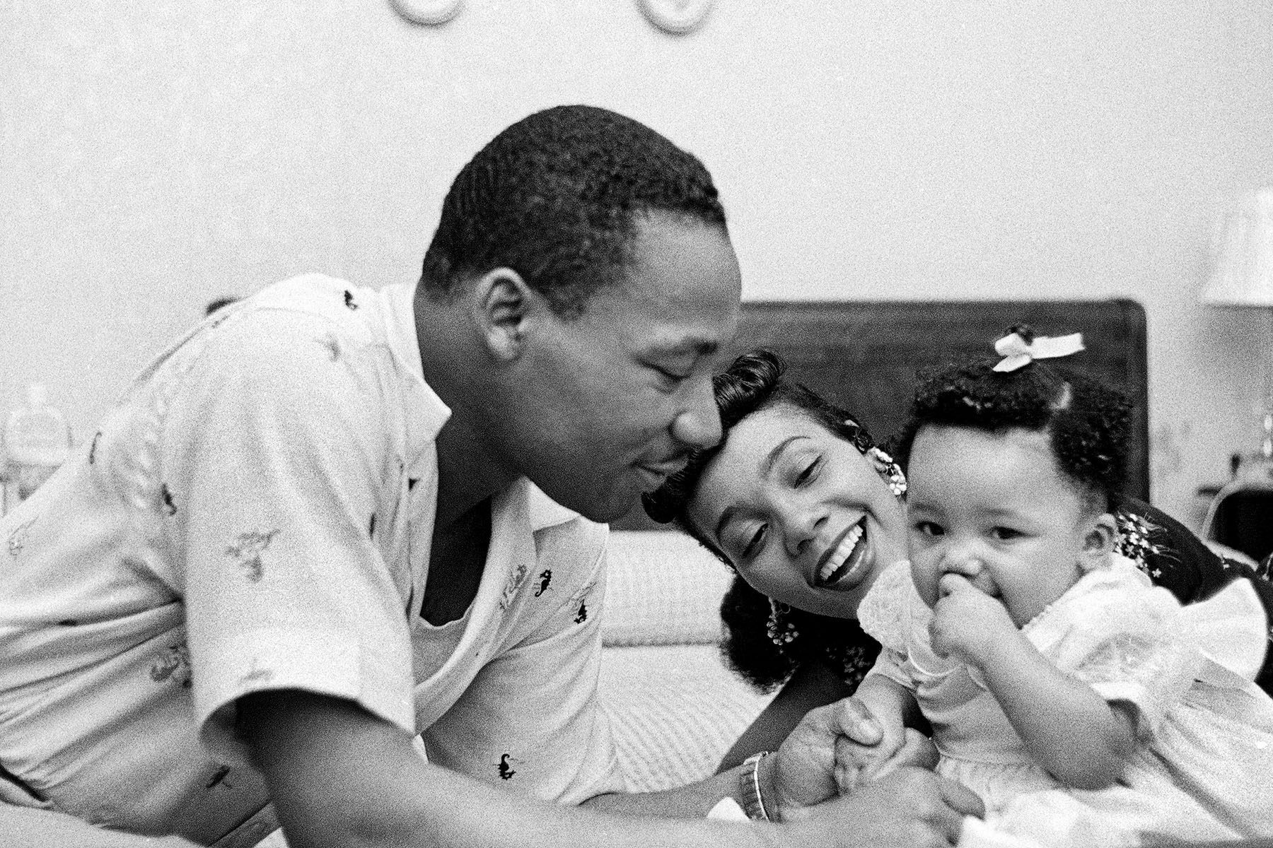 MLK Jr. plays with his daughter Yolanda while his wife holds her.