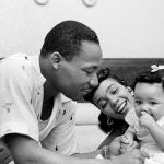 MLK Jr. plays with his daughter Yolanda while his wife holds her.