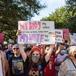 Protesters carry pro-abortion rights signs and march.