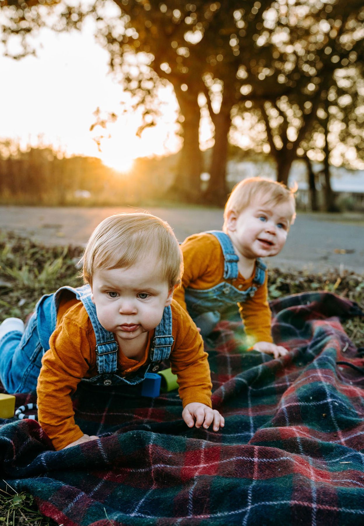 Portrait of Catherine Dicicco's twins playing on a blanket at sunset.