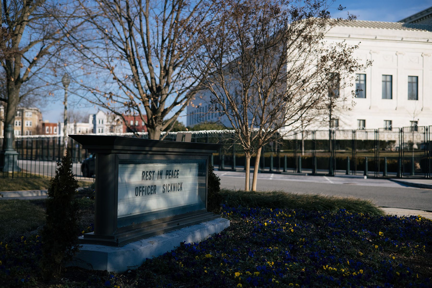 A sign reads "Rest in peace officer Sicknick" outside the United Methodist Building.