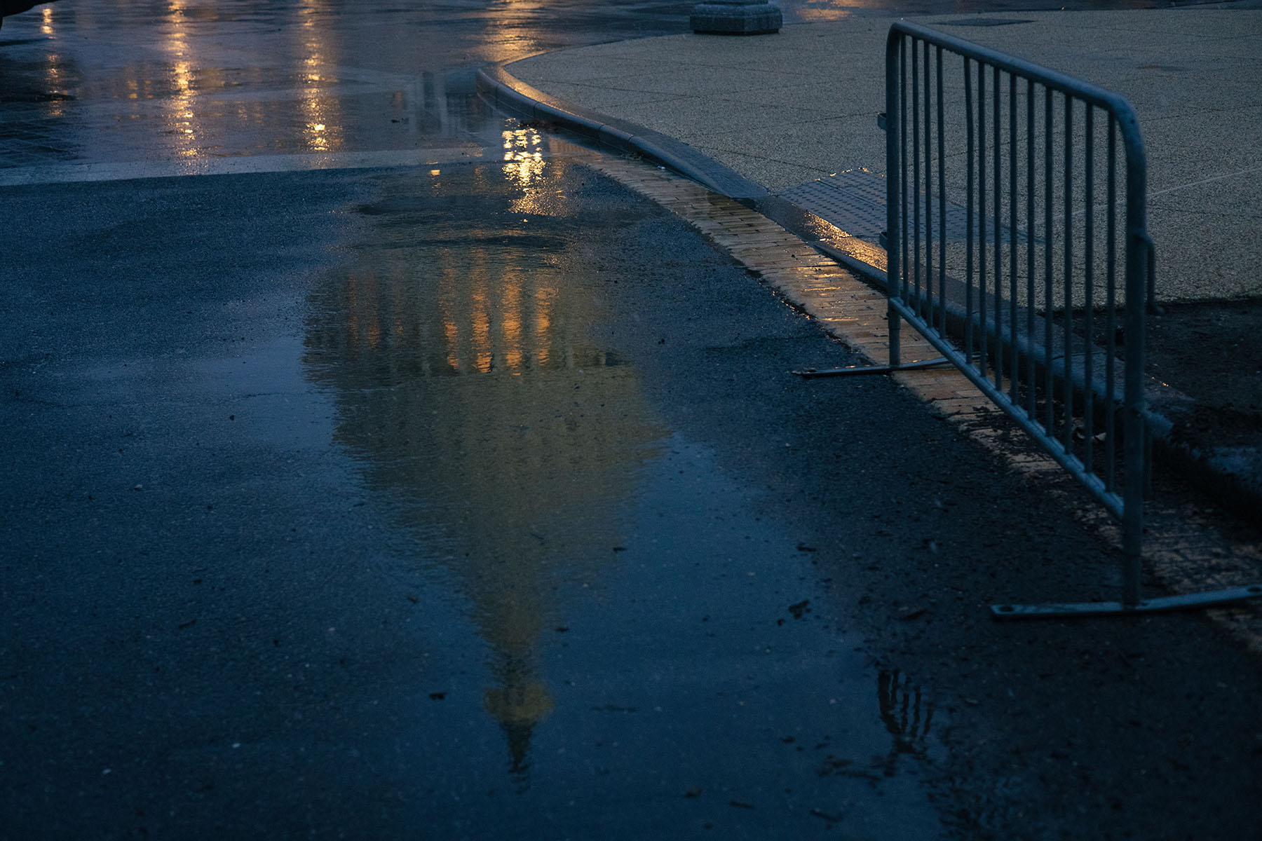 The U.S. Capitol is reflected in rain water.