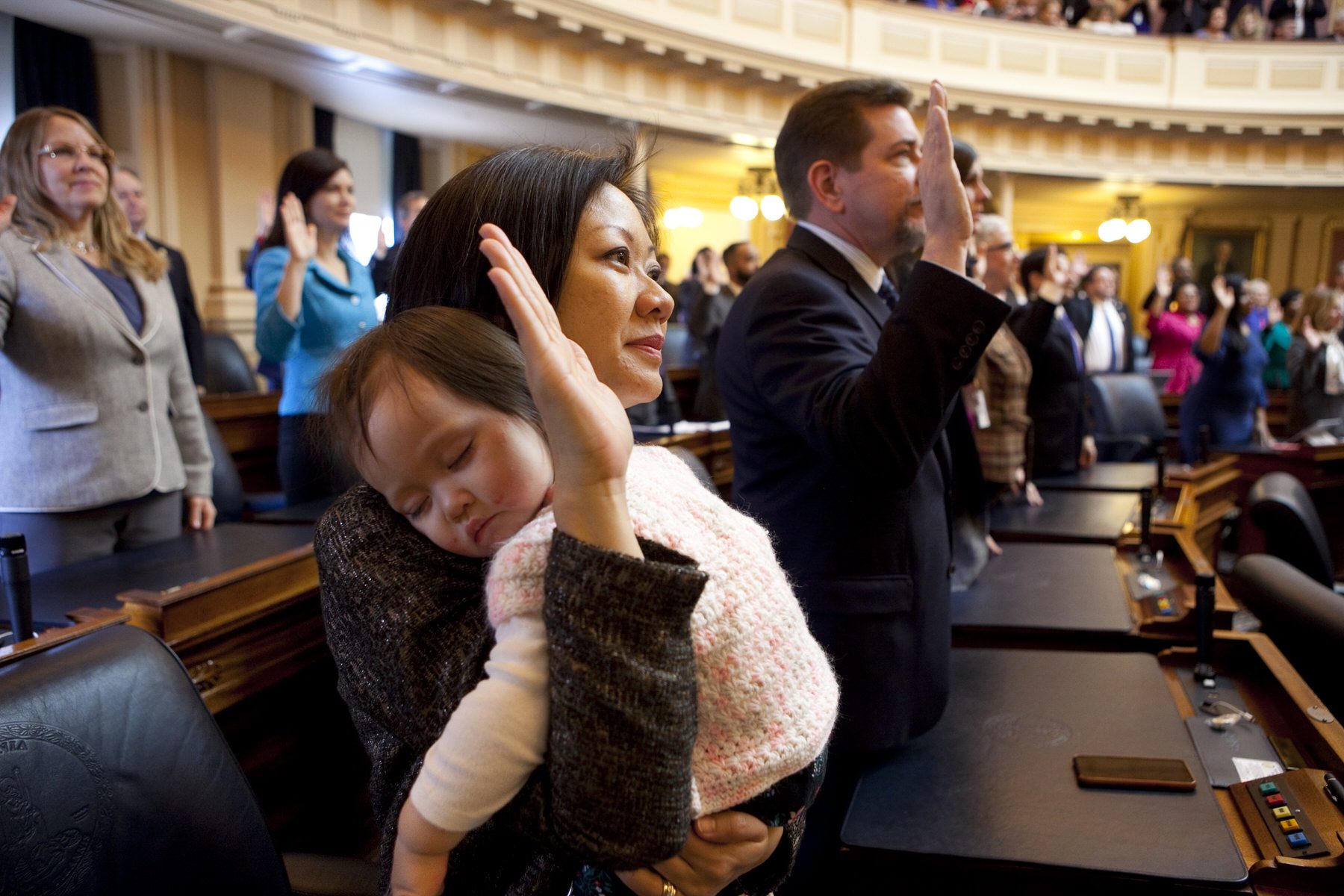 Del. Kathy Tran holds her daughter while being sworn in