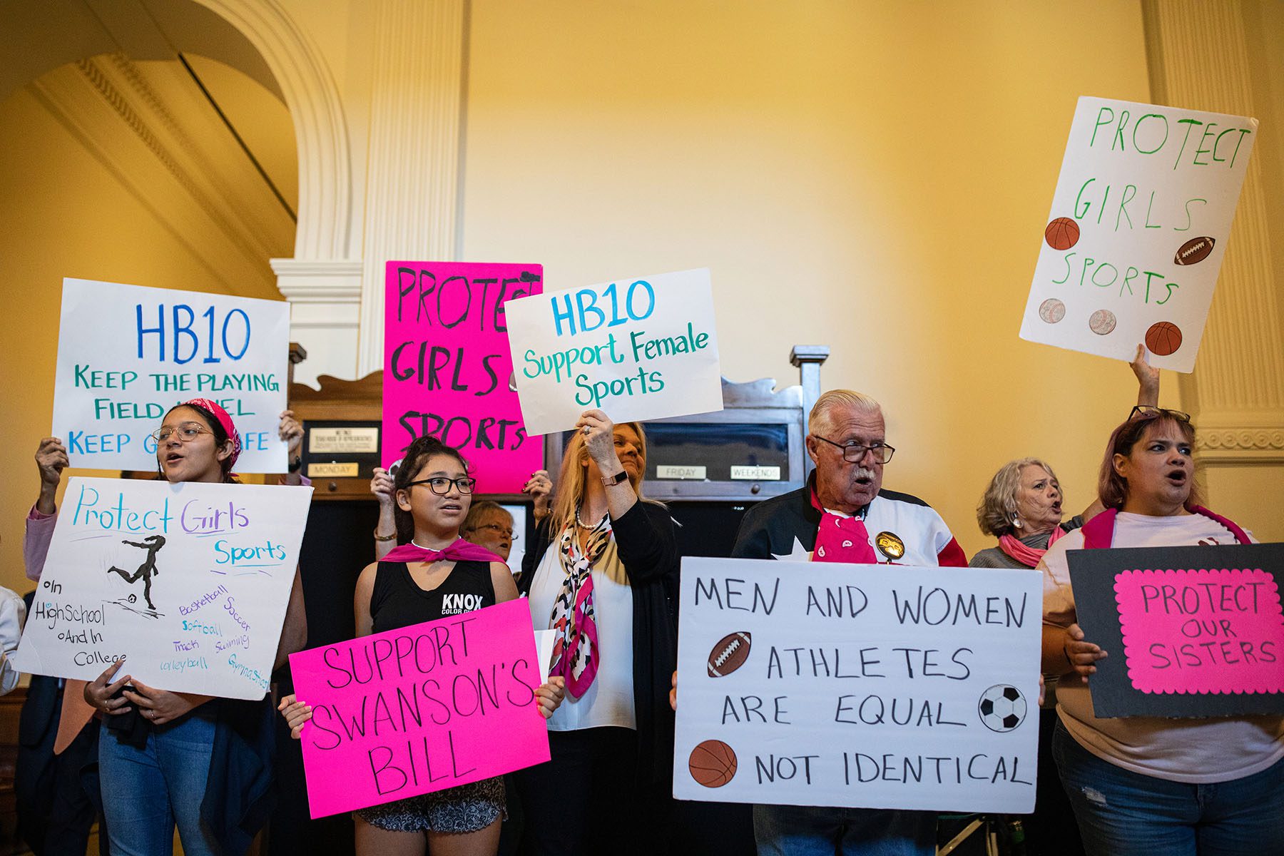 People hold signs in support of anti-trans bills at the Texas State Capitol