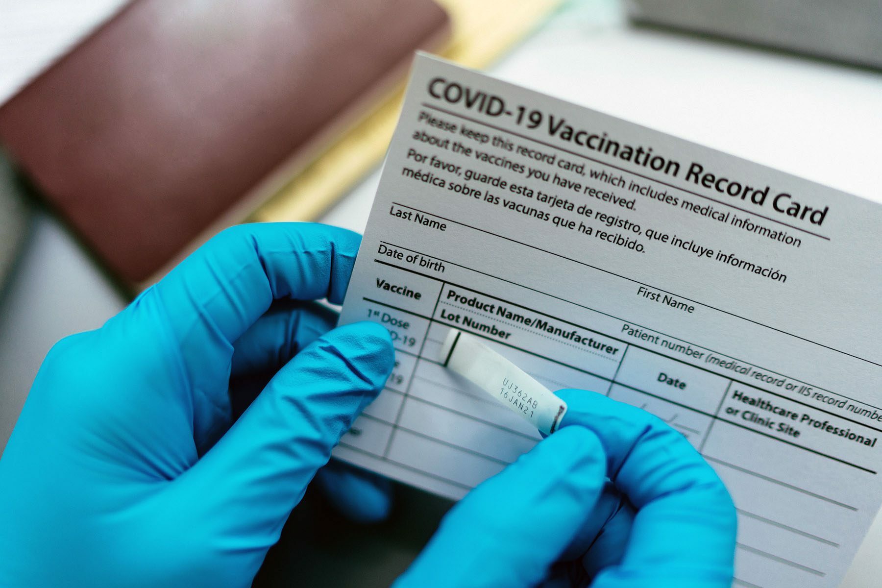 A nurse adds a label to a COVID-19 vaccination card