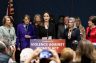 Angelina Jolie stands with women senators at a lectern that says 