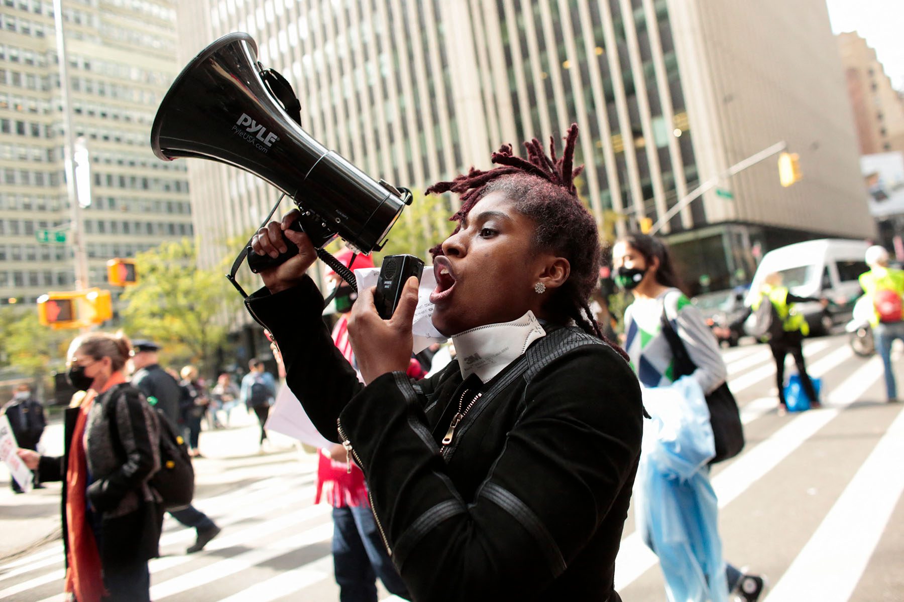 A demonstrator shouts slogans through a megaphone as she marches.