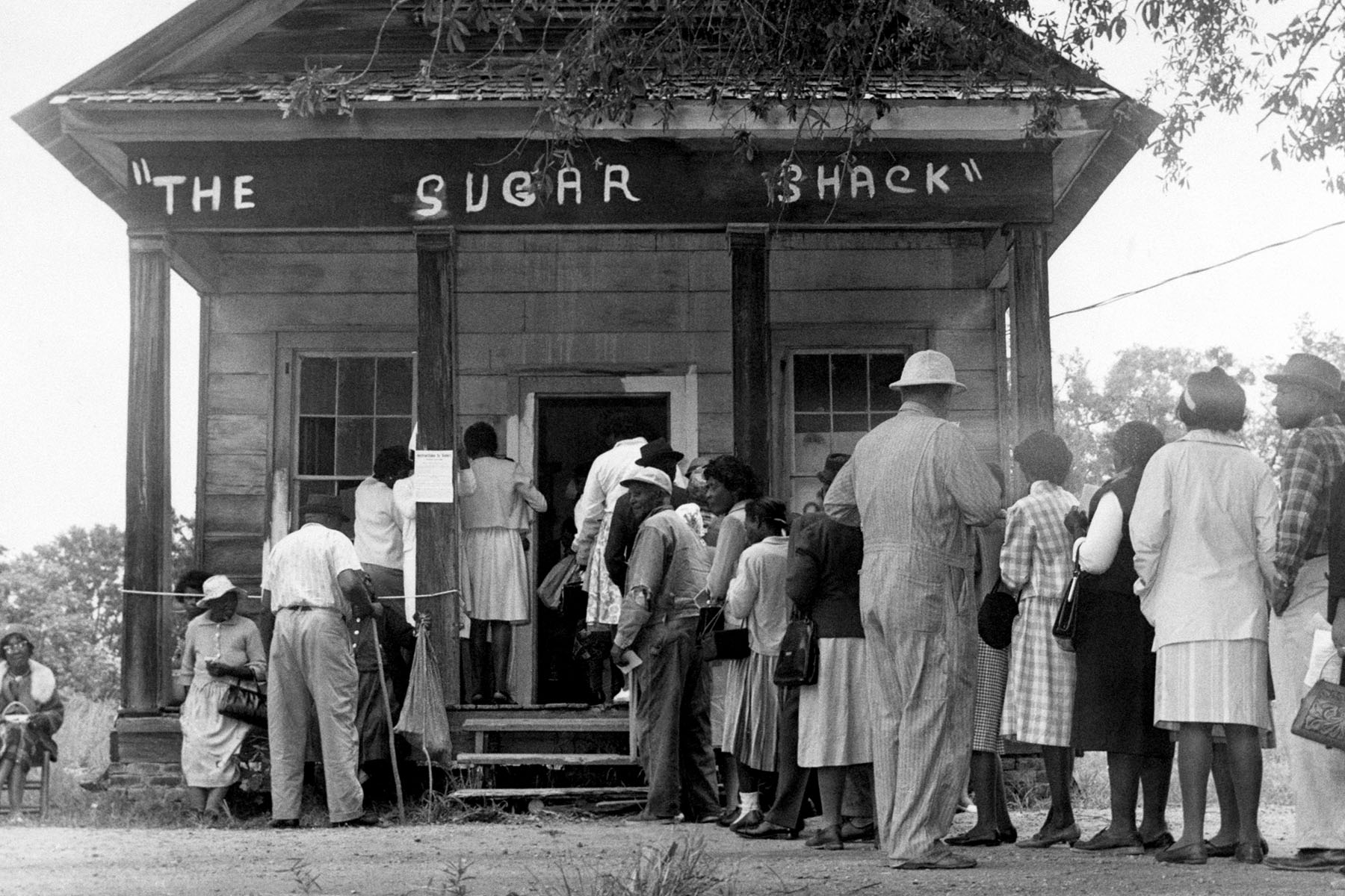 First time voters line up in front of a small general store turned polling station.