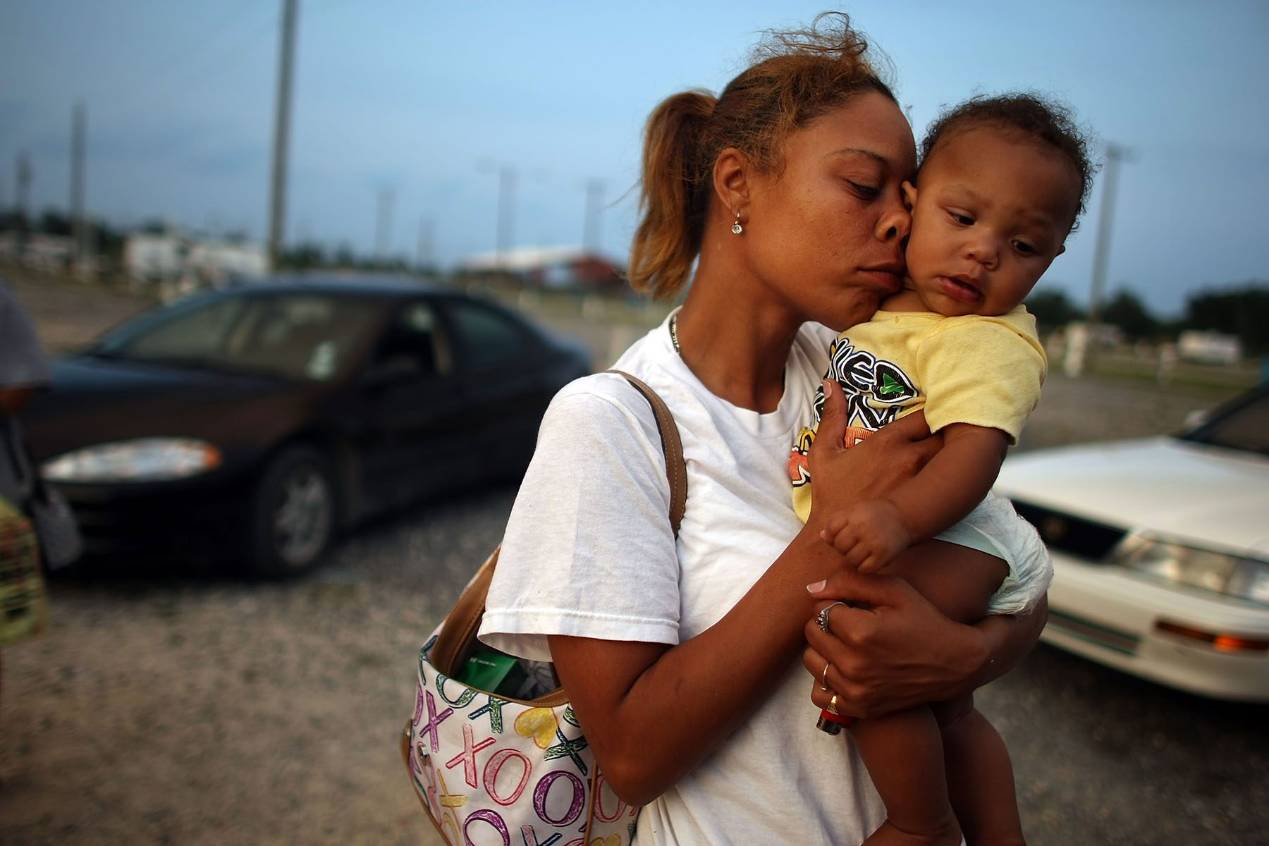 Shelly Phillips holds niece Kimmore Barthelemy in her arms in a trailer park.