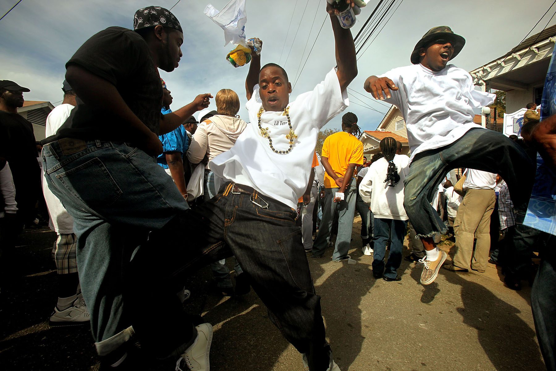 People are captured jumping up in the air mid-dance in the streets of New Orleans.