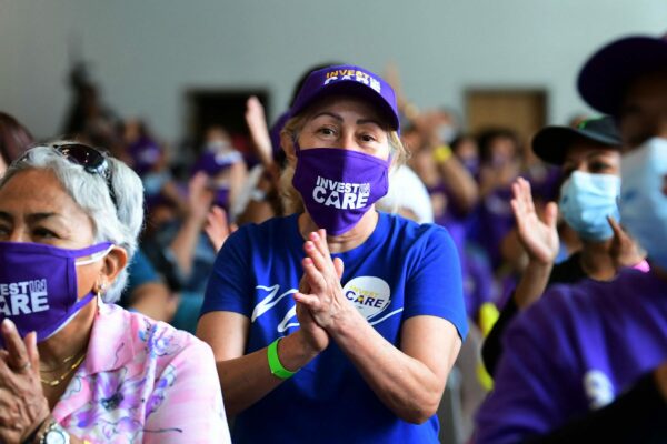 Caregivers smile and applaud during a rally.