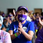 Caregivers smile and applaud during a rally.