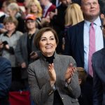 Kim Reynolds cheers and claps from the crowd at a 