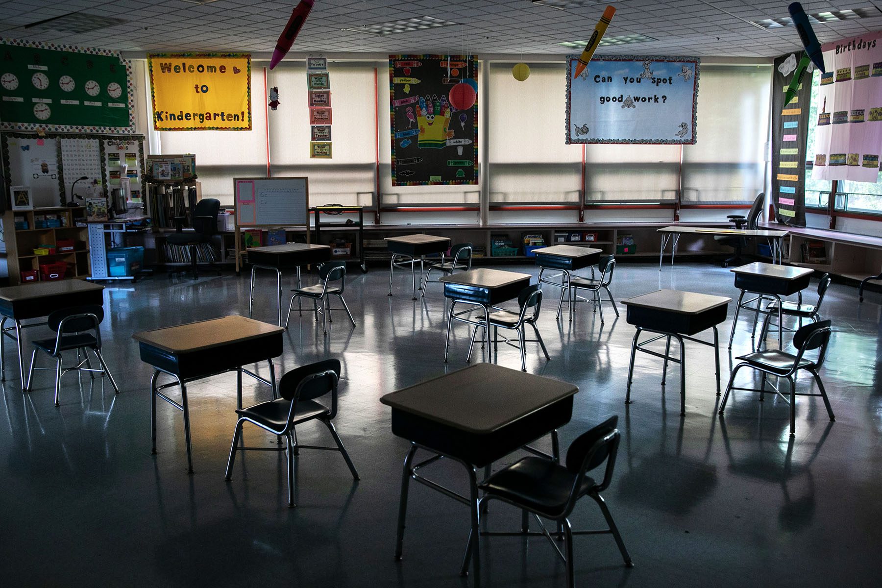 Socially distanced desks stand in an empty classroom.