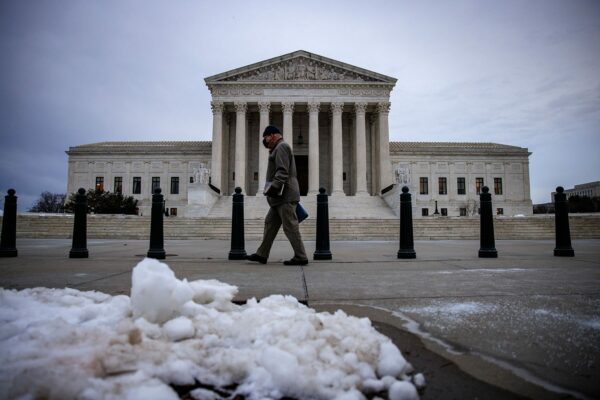 A man walks past the U.S. Supreme Court following a snowfall.
