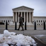 A man walks past the U.S. Supreme Court following a snowfall.