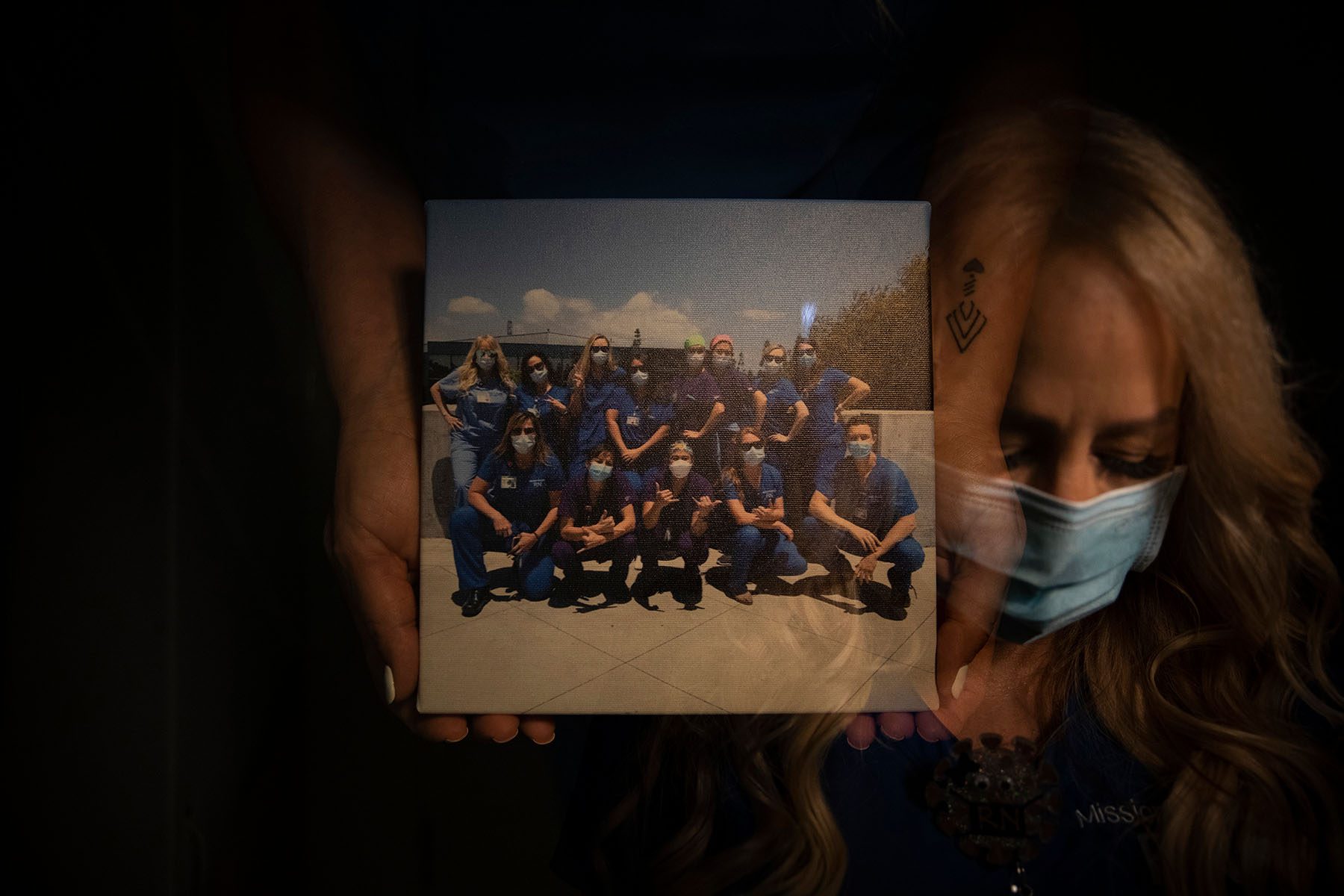 A nurse holds a group picture taken with fellow nurses.
