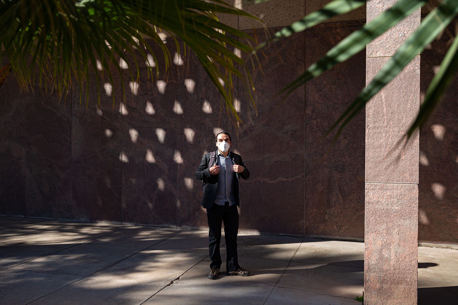 Sen. Mendez wears a mask as he poses for a portrait near the Arizona State Capitol.