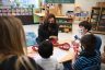 Vice President Kamala Harris speaks with children in a classroom.