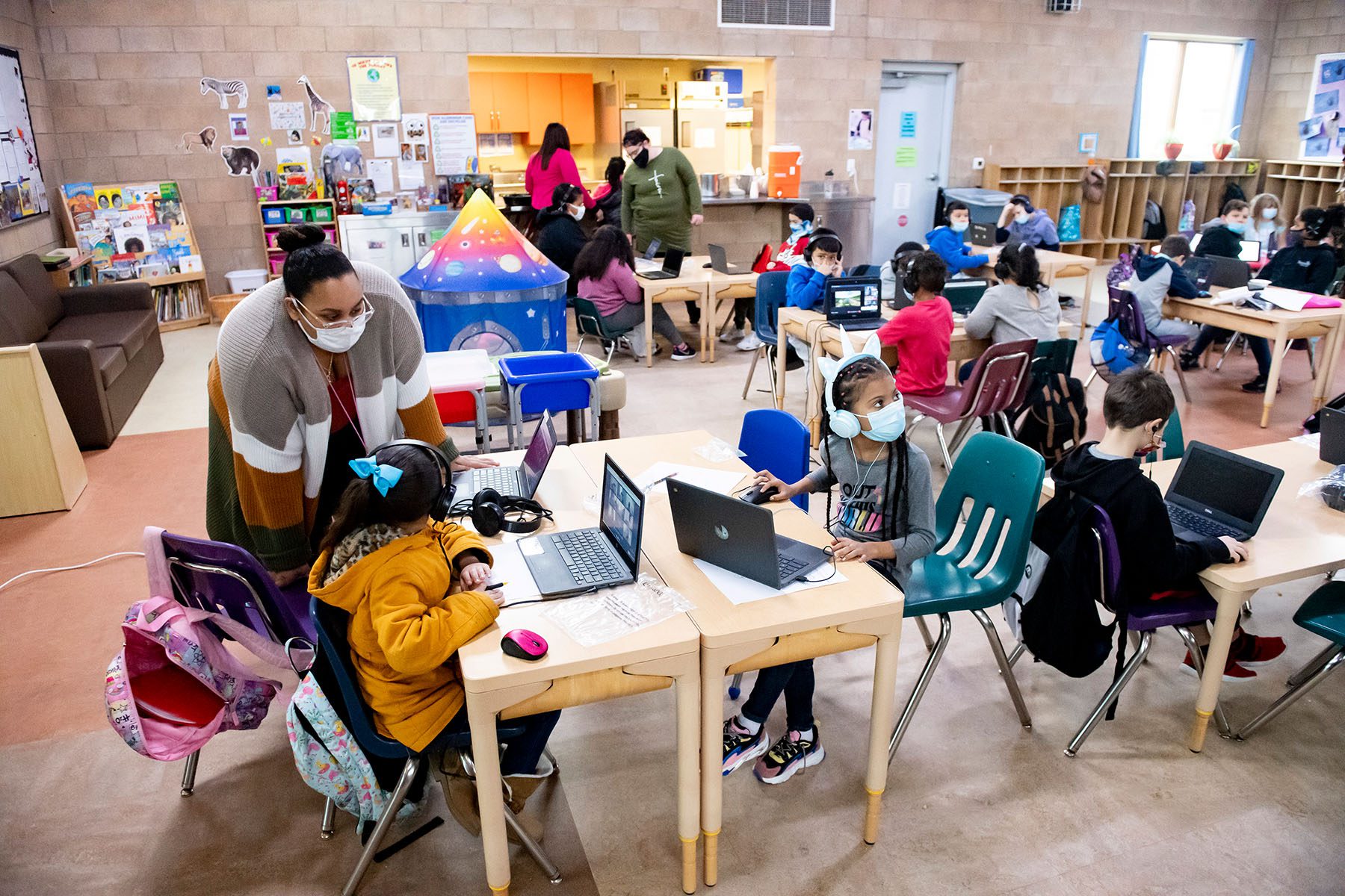 Children on laptops attend remote learning school at a learning center.